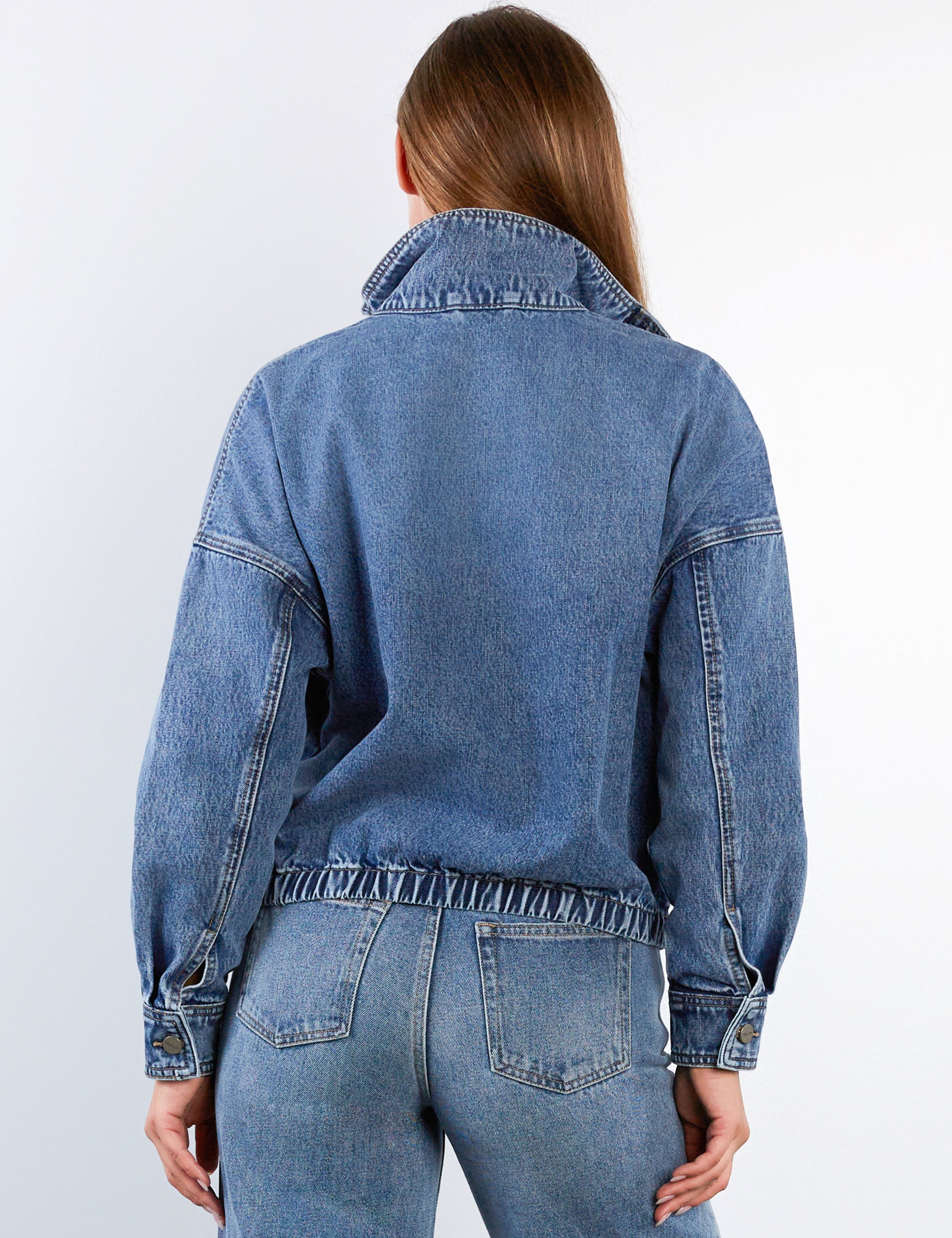 Woman wearing a blue denim bomber jacket