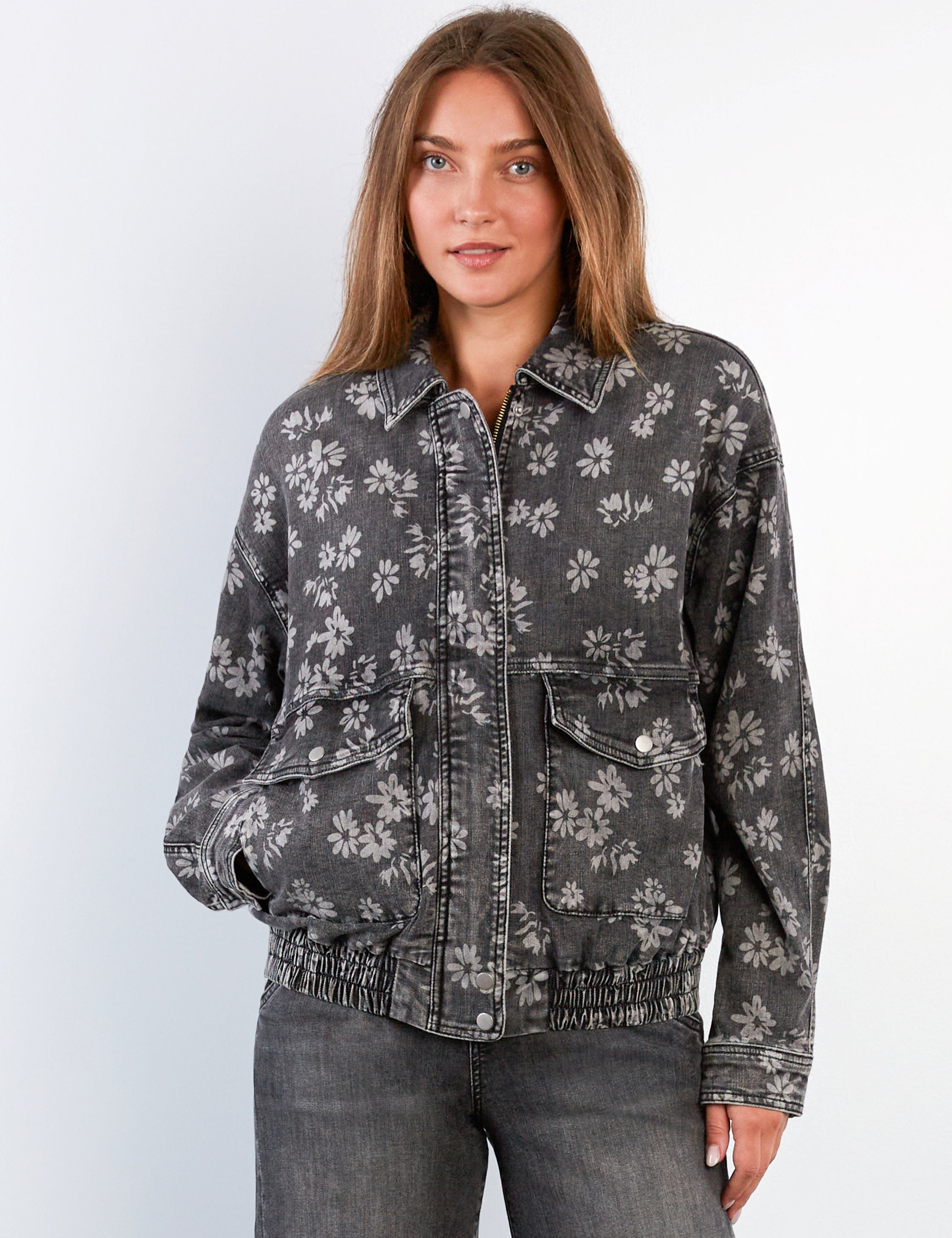 Woman wearing a floral patterned jacket on a plain background