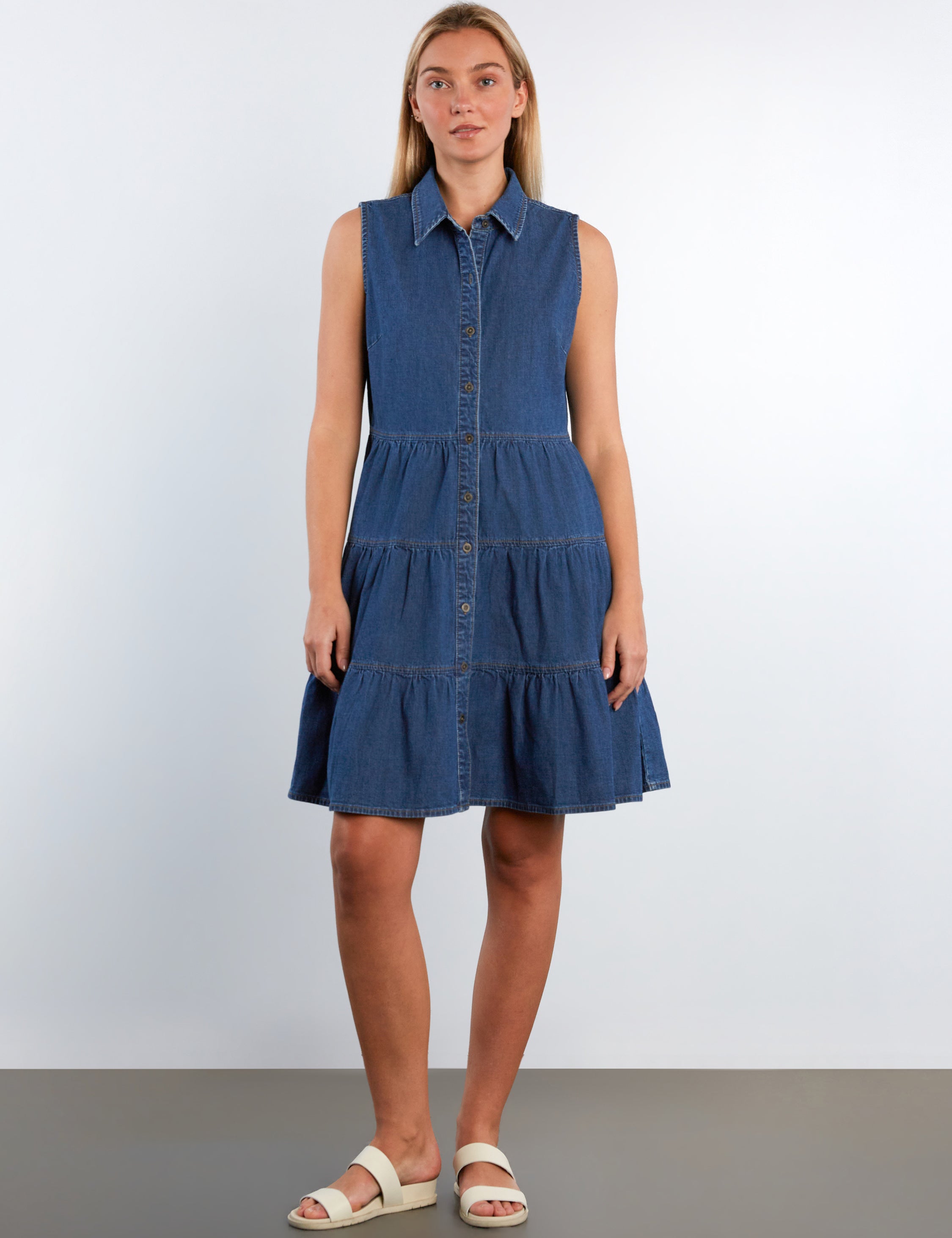 Woman wearing a blue denim dress against a white background